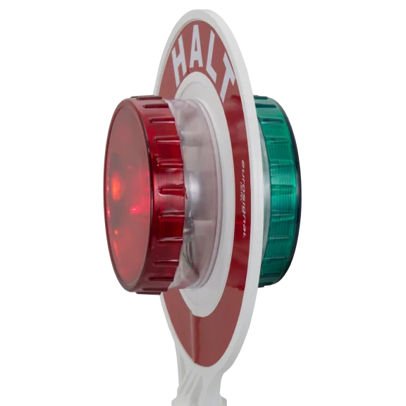 Detailansicht der Winkerkelle mit roter LED-Leuchtlinse auf der „HALT“-Seite, gegenüberliegend grüne Rückseite mit „STRASSE FREI“.