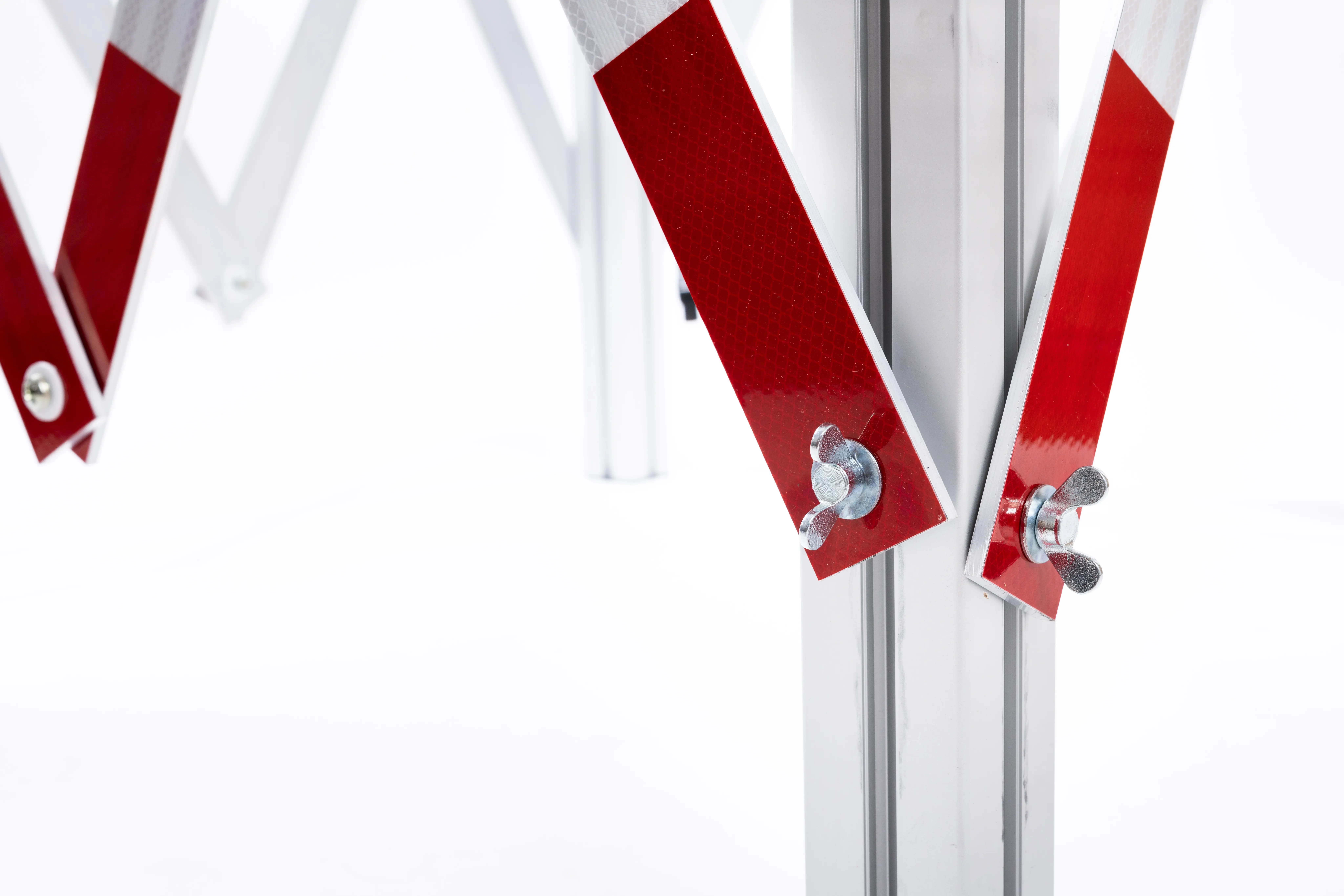 Detailansicht einer Alu-Schachtabsperrung mit rot-weißen Reflektoren und Flügelschrauben zur Fixierung